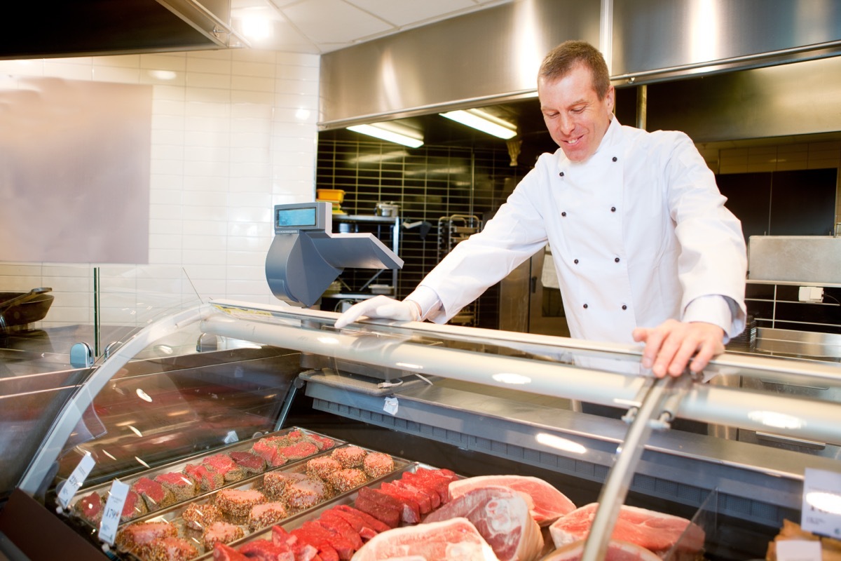 butcher behind meat counter