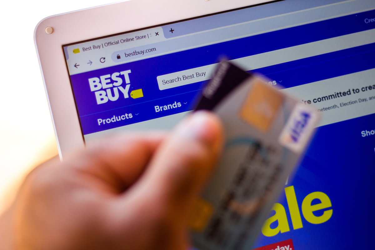 Best Buy website and hand holding a credit card