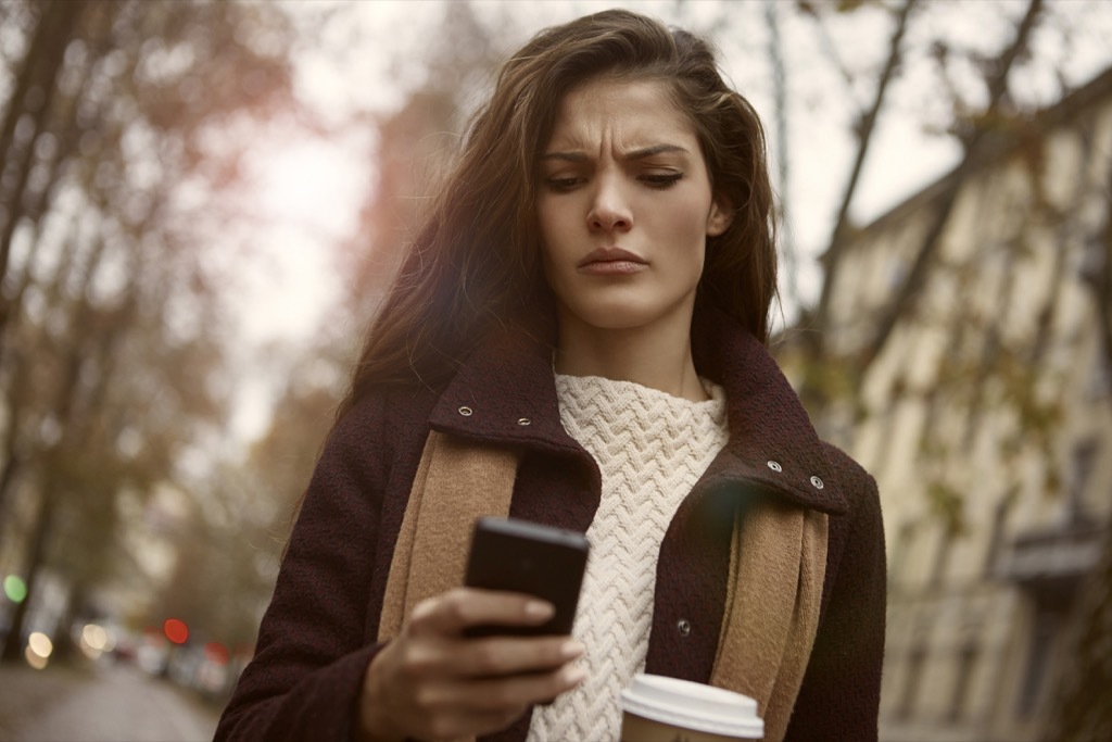 woman checking phone surprised shocked