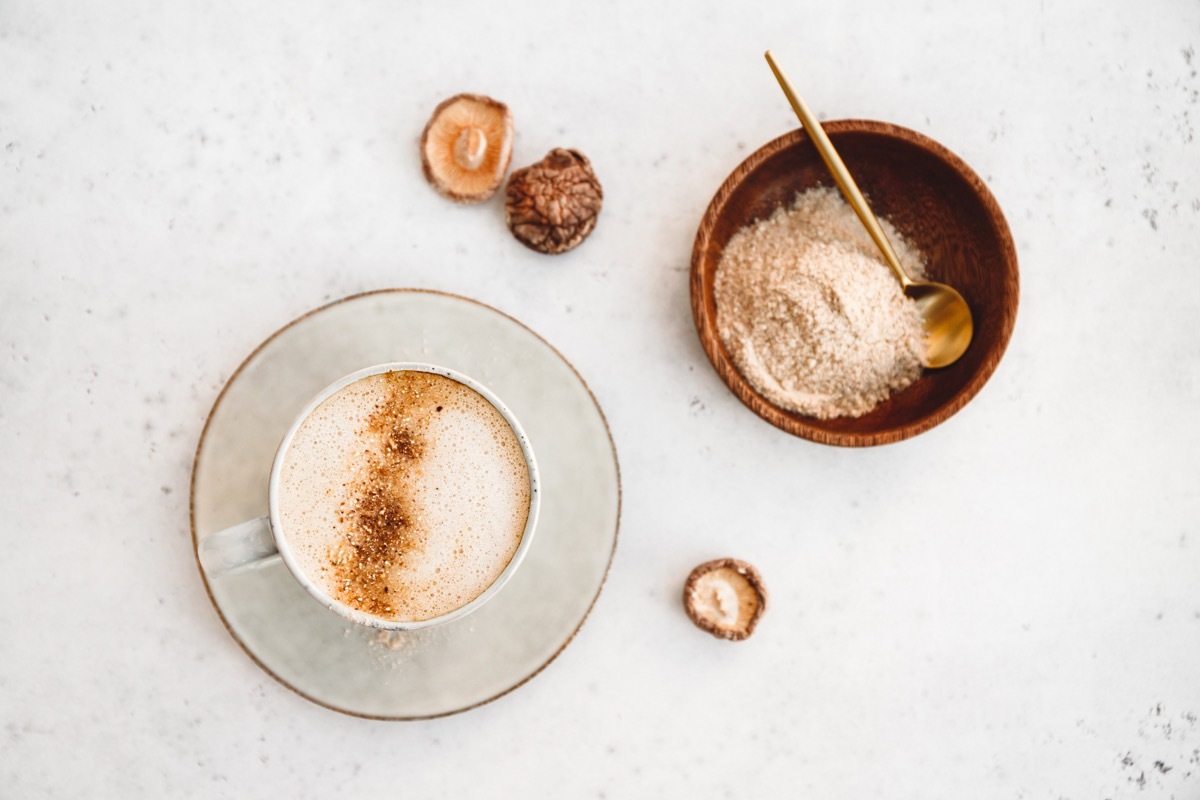 Top view of mushroom latte with shiitake powder and unsweetened coconut-almond blend milk. Healthy useful vegan drink, flat lay. (Top view of mushroom latte with shiitake powder and unsweetened coconut-almond blend milk. Healthy useful vegan drink, fl