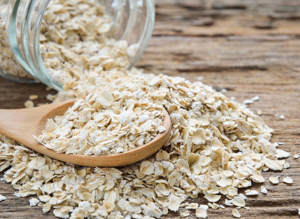 Oatmeal falling out of jar onto spoon and table