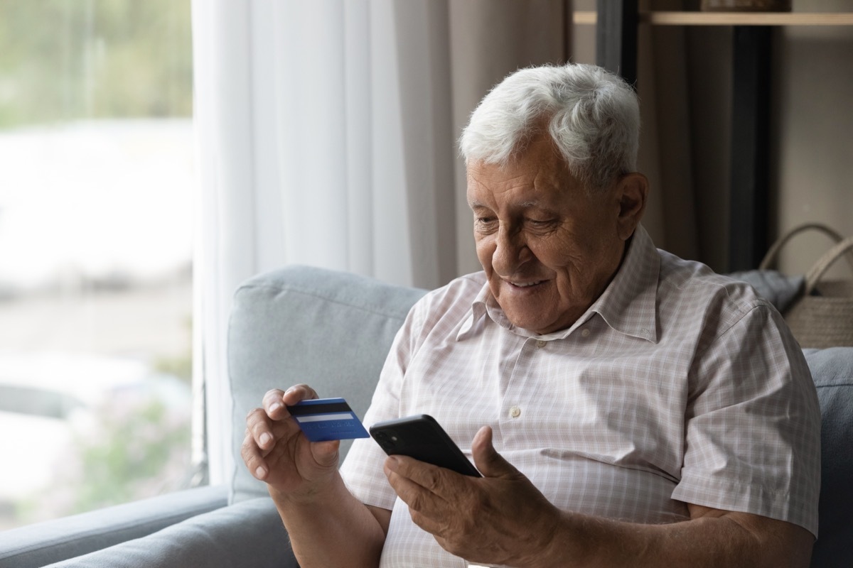 mature man enjoying cashback deals on a credit card purchase