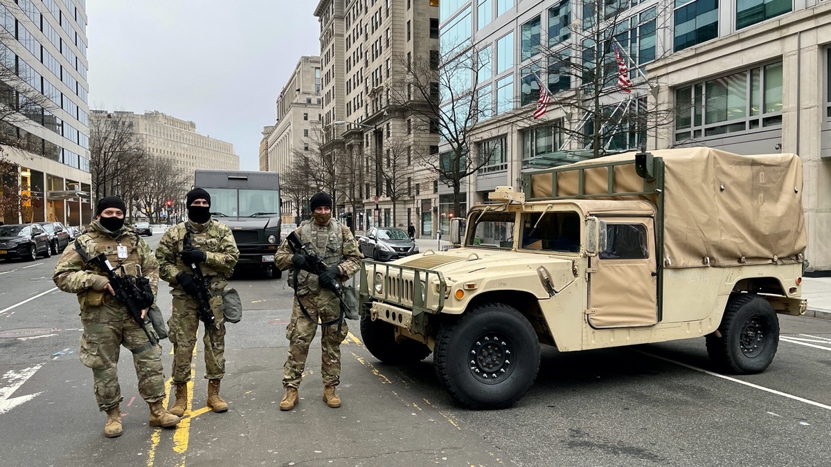 national guard members stand outside a military vehicle on a washington dc street