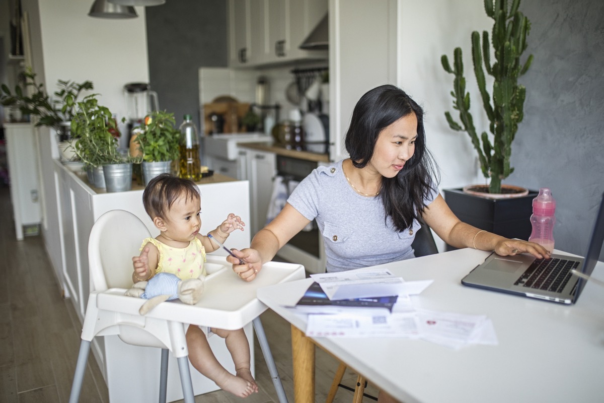 Young mother working and spending time with baby at home