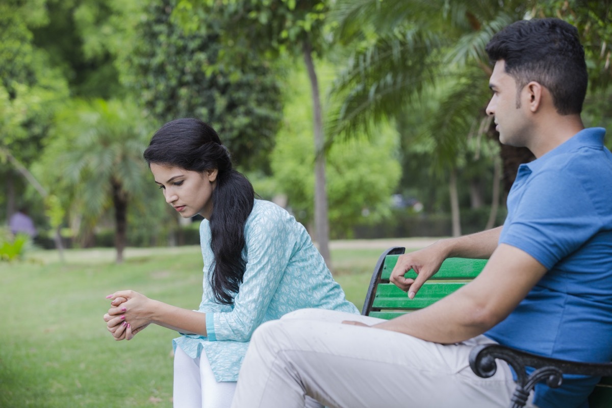 dating couple arguing in silence on a park bench