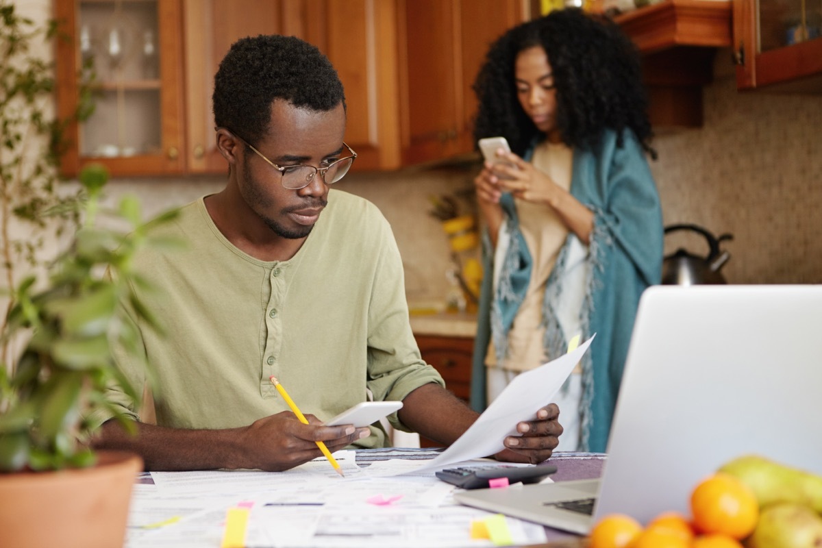 man looking concerned while paying bills