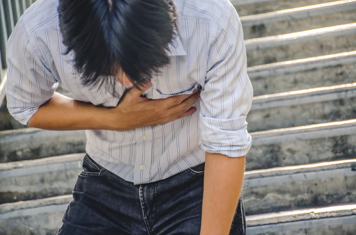 young asian man clutching chest on stairs, signs your cold is serious