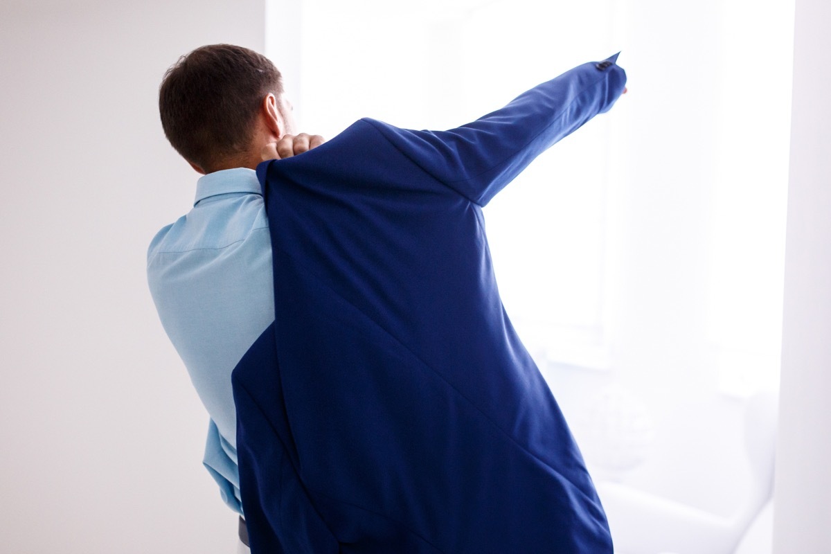 man putting arm through armscye in jacket