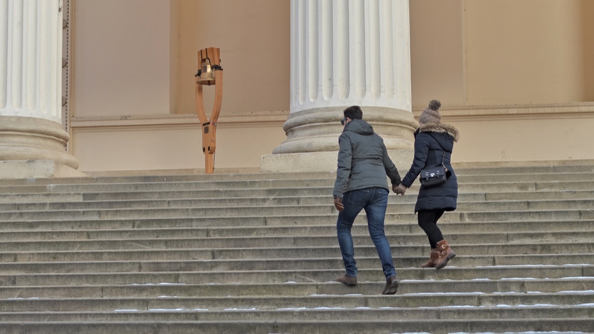 Man and woman holding hands and walking up museum steps