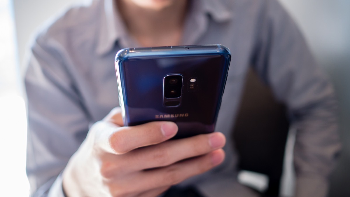 Bangkok, Thailand - May 19th 2018 : A man in gray shirt use blue Samsung galaxy S9 plus, Andriod mobile phone.