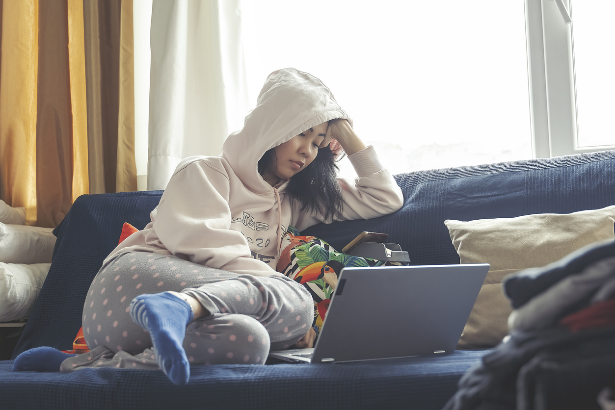 Woman sitting on the couch watching something on her laptop.