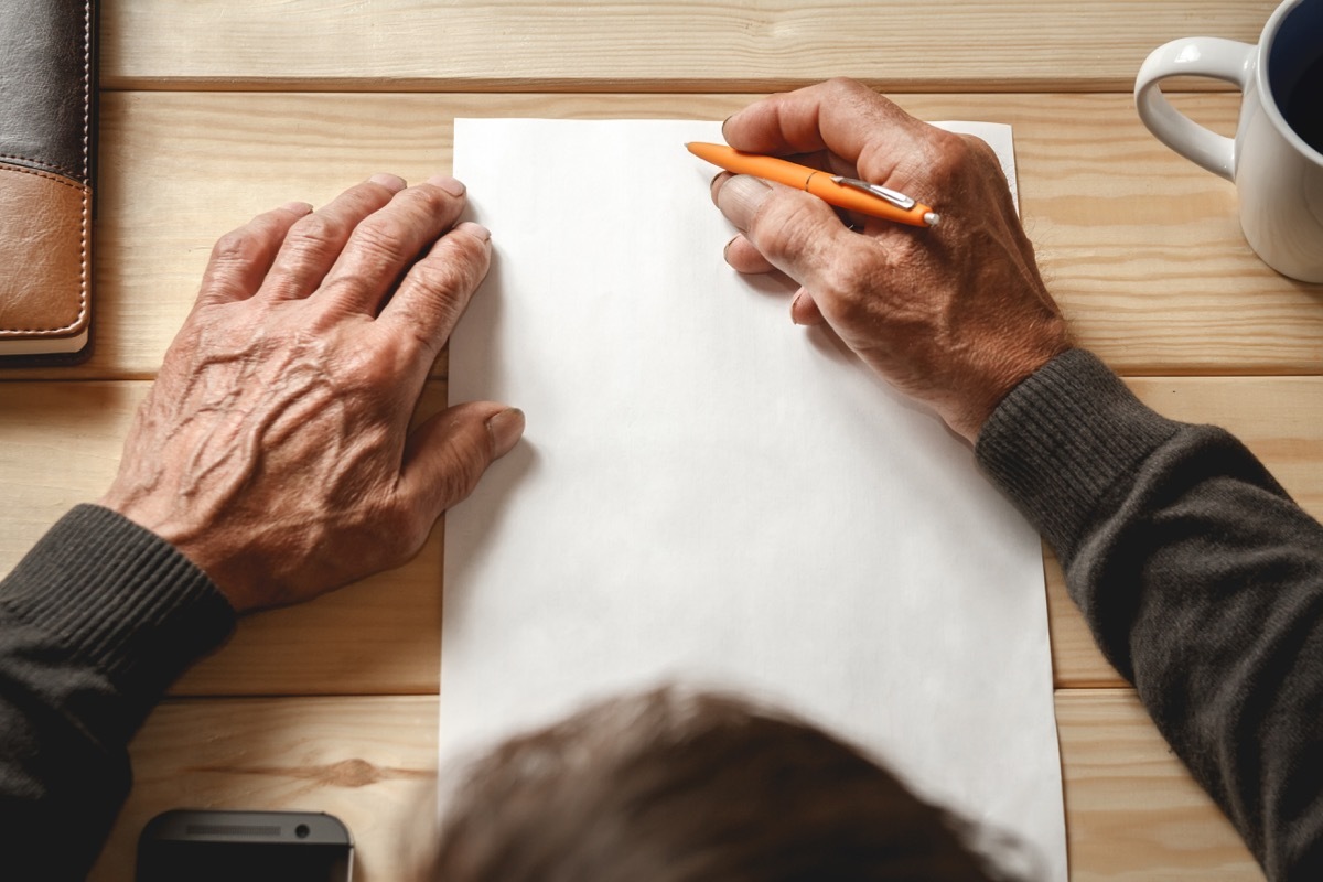 Older person writing on paper