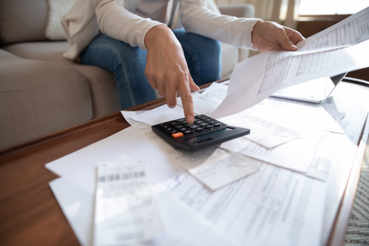 Woman going through bills and receipts at coffee table