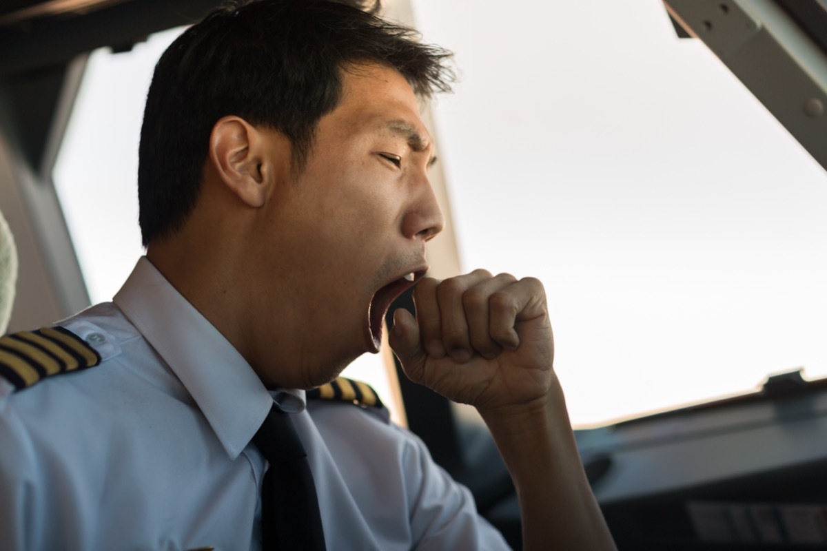 Tired man yawning at work.