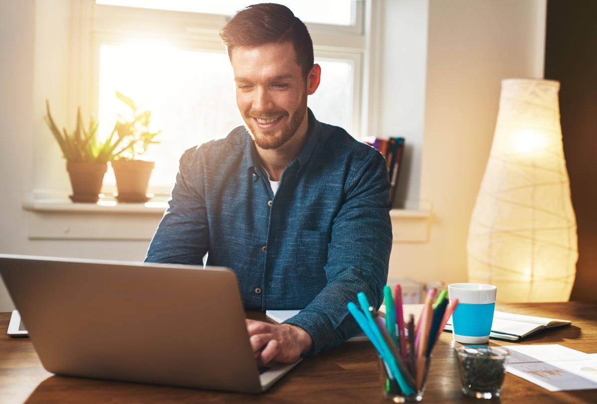 young white man in wfh office working from home in front of window