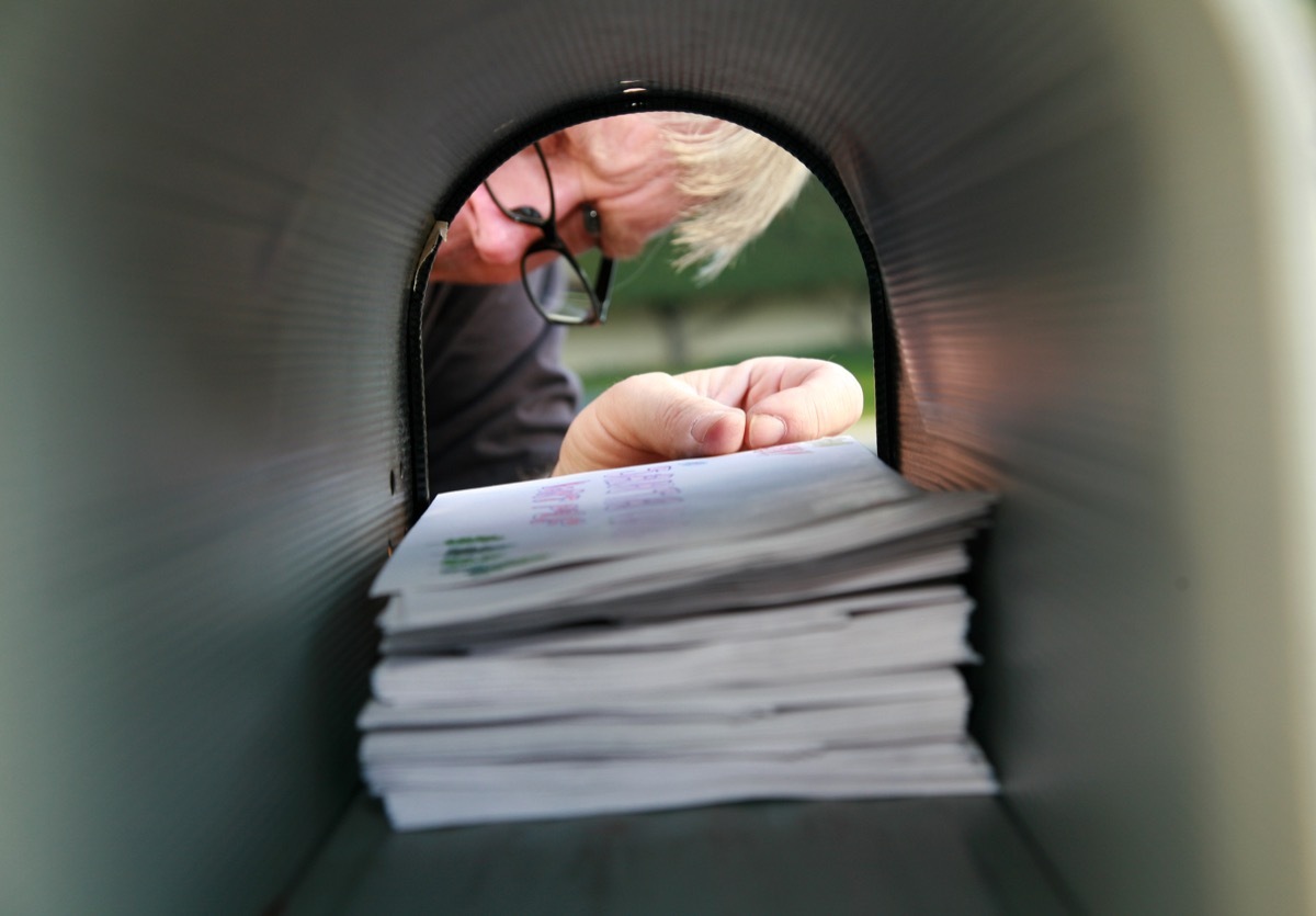 A man delivering or receiving mail in a mailbox