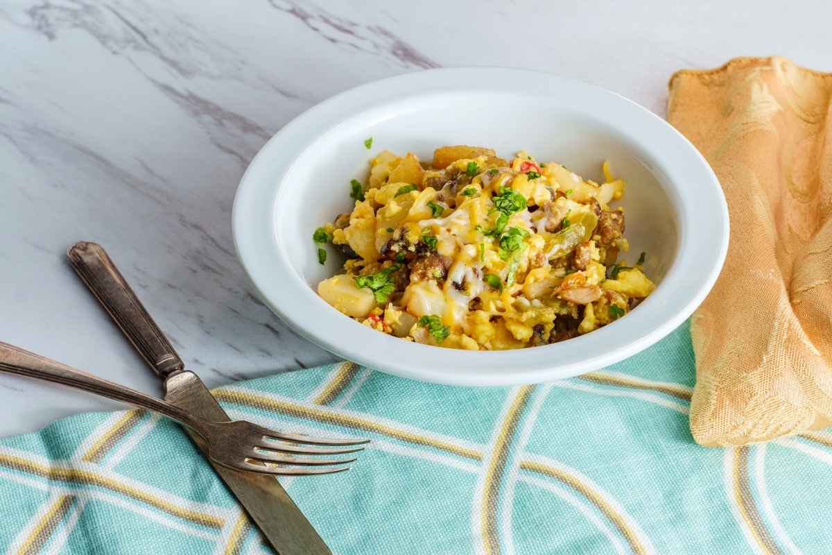 Breakfast egg scramble bowl with sausage potatoes mushrooms and cheddar cheese