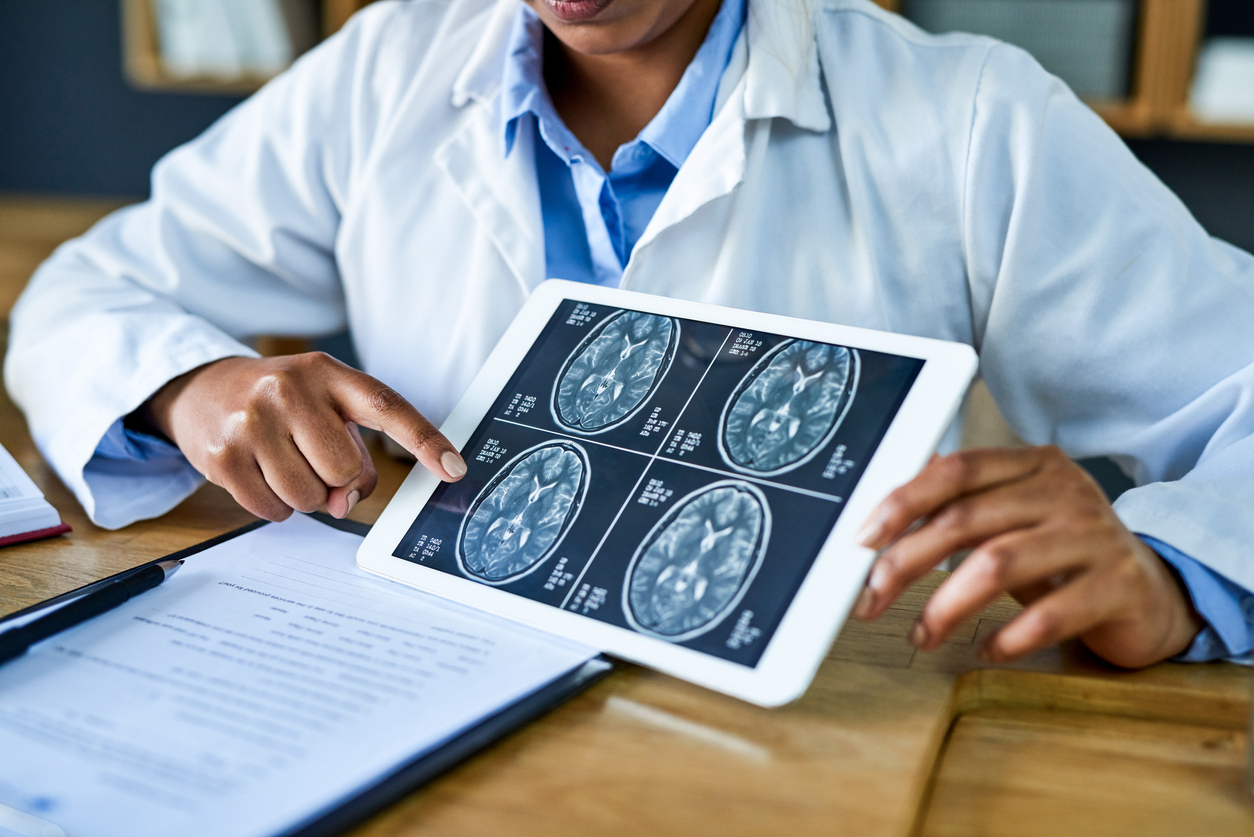 Doctor using a digital tablet to discuss a brain scan.