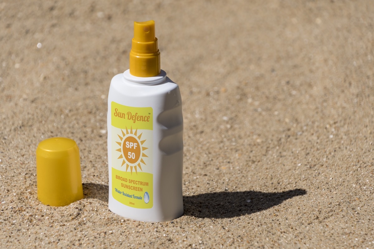 Bottle of sunscreen on the beach.